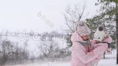 雪天，快乐的女人用温暖的连衣裙抱着婴儿。 微笑妈妈和女儿一起玩